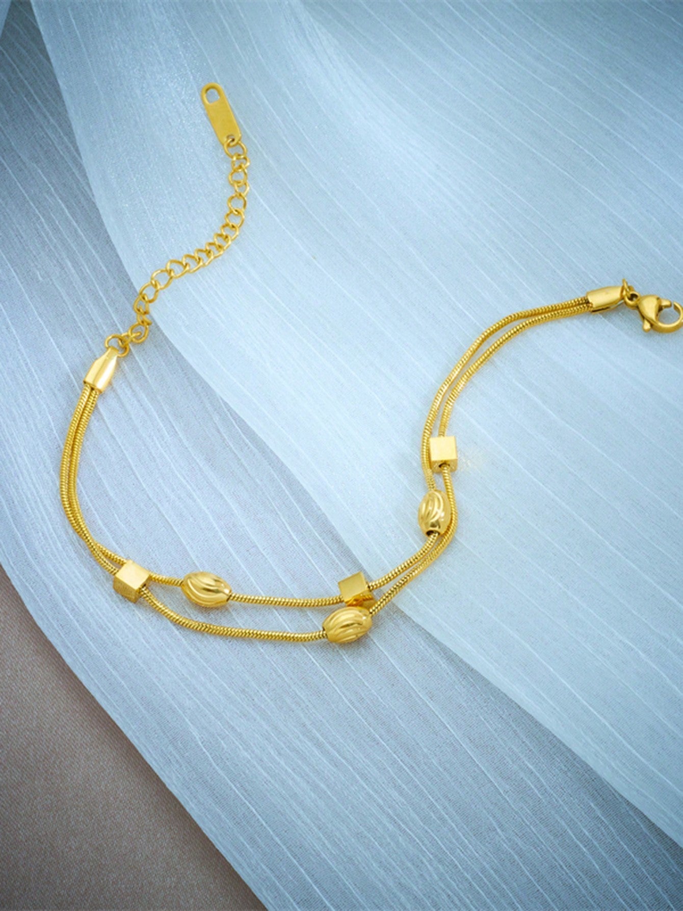 Double layer woven studded chain bracelet in gold plated stainless steel with screw-in fastening
