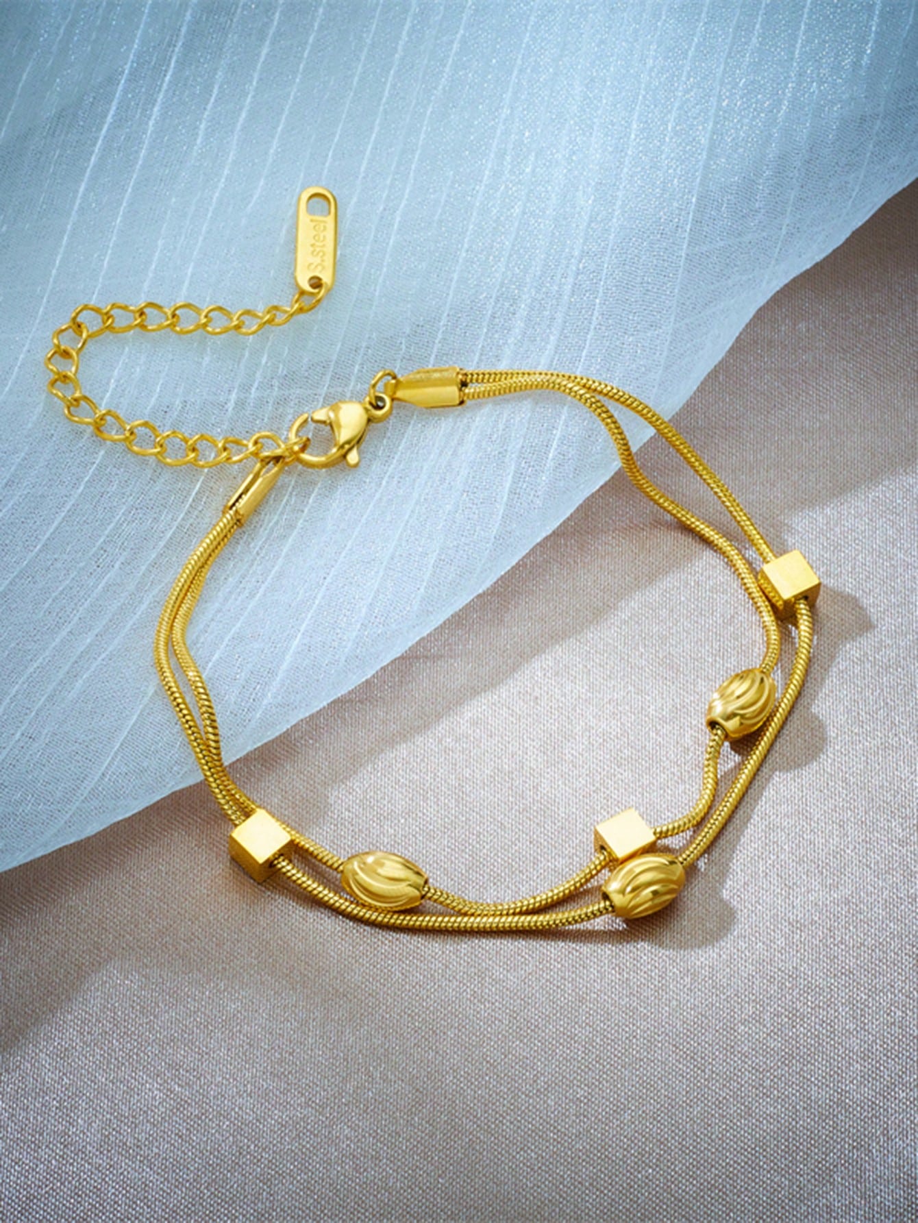 Double layer woven studded chain bracelet in gold plated stainless steel with screw-in fastening